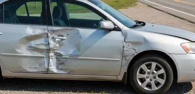 Two vehicles with side damage pulled onto Oregon highway shoulder with State Police trooper documenting the scene